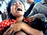 A woman grasps her child outside an Indonesian hospital, one of many overwhelmed by victims after mass flooding on Sunday.